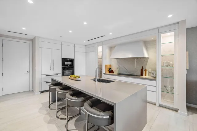 a kitchen with a table chairs refrigerator and cabinets