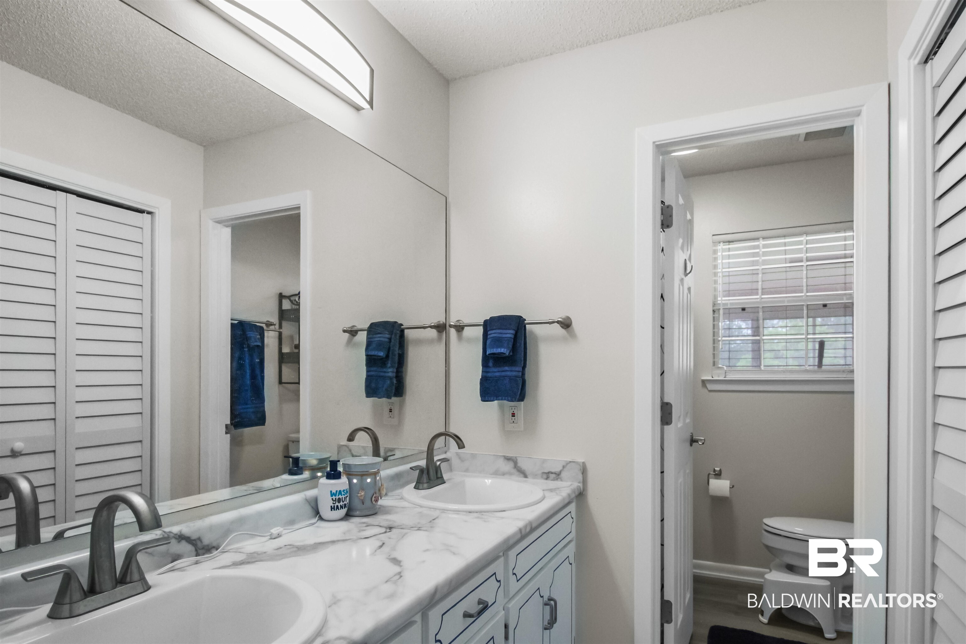 26850 Timber Lane Elberta, AL 36530 - Photo 16 of 33 Bathroom featuring a closet, double vanity, toilet, and a textured ceiling