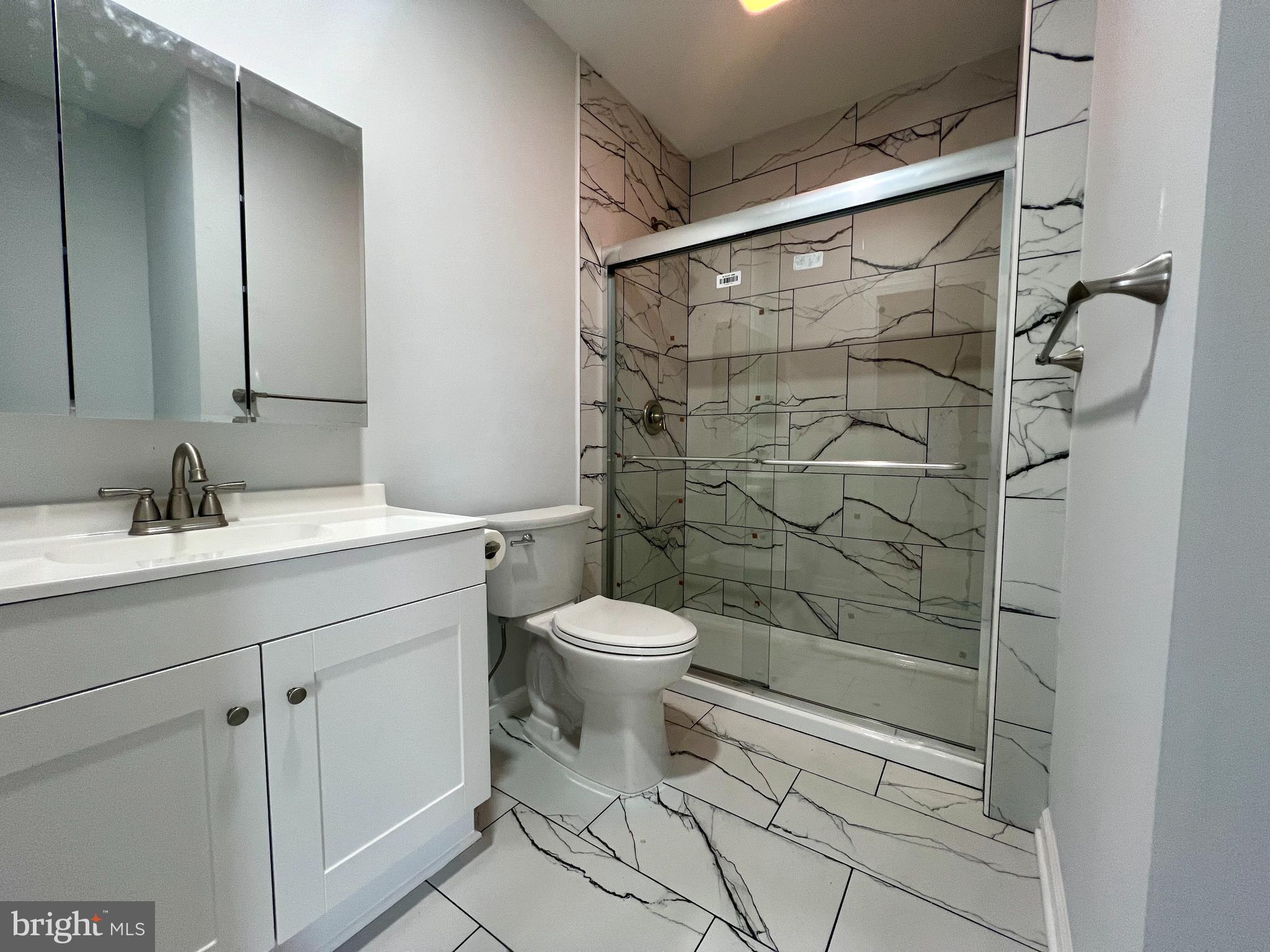 509 Lumberton Road, Unit 2 Hainesport, NJ 08036 - Photo 7 of 13 a bathroom with a shower toilet sink and mirror