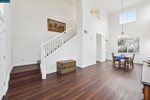 a view of dining room and livingroom with furniture wooden floor windows and a chandelier