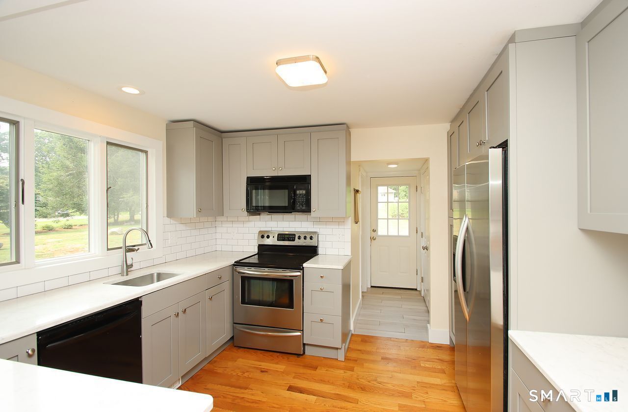 141 Duck Hole Road Madison, CT 06443 - Photo 12 of 22 a kitchen with a sink a counter top space and stainless steel appliances