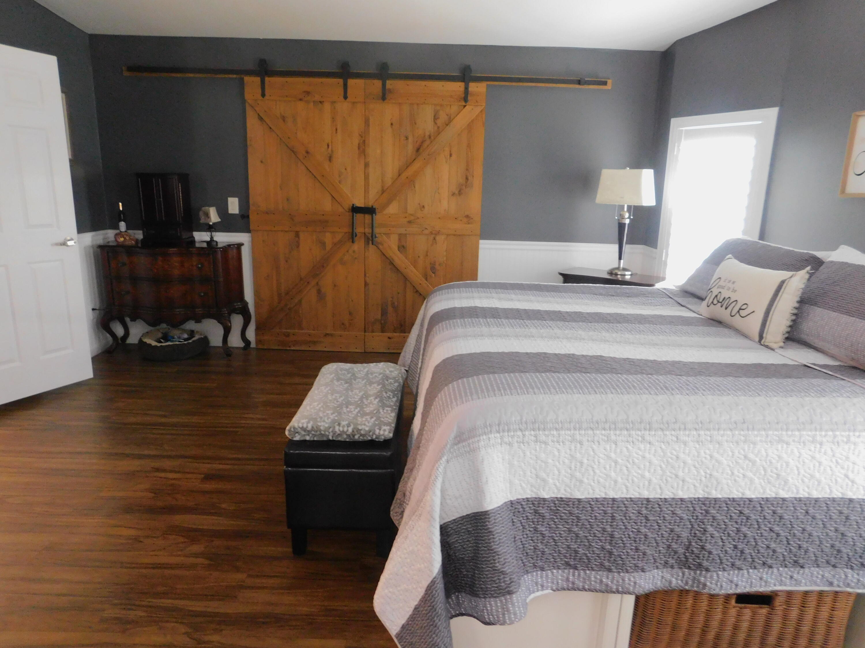 529 Hemingway Terrace, Unit 8 Fort Pierce, FL 34982 - Photo 18 of 24 a bedroom with a bed and wooden floor