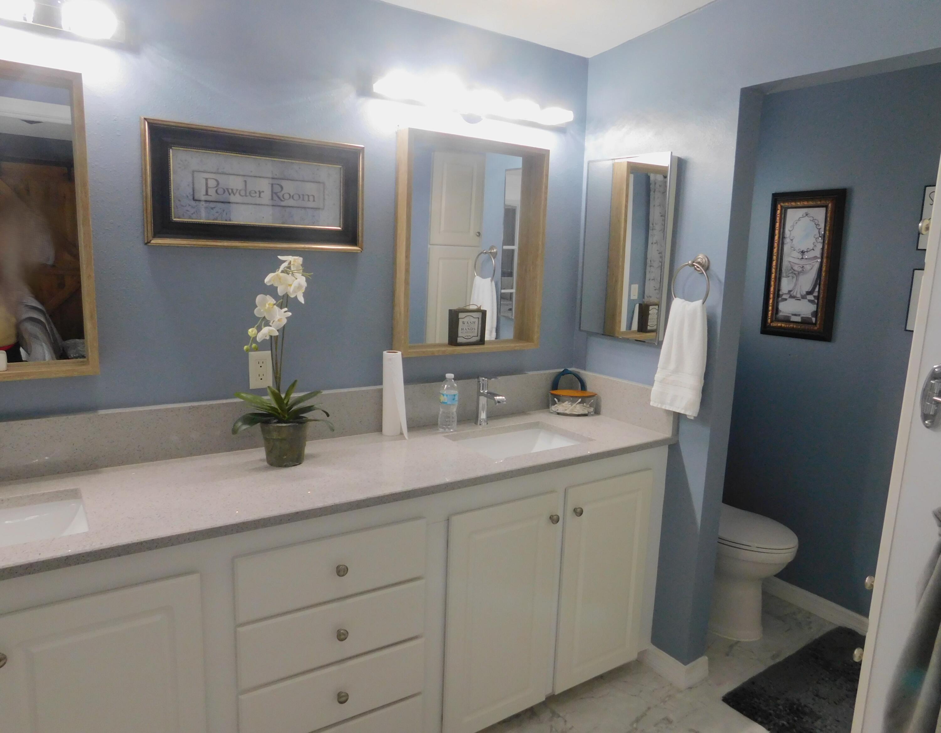 529 Hemingway Terrace, Unit 8 Fort Pierce, FL 34982 - Photo 19 of 24 a bathroom with a granite countertop sink mirror and toilet