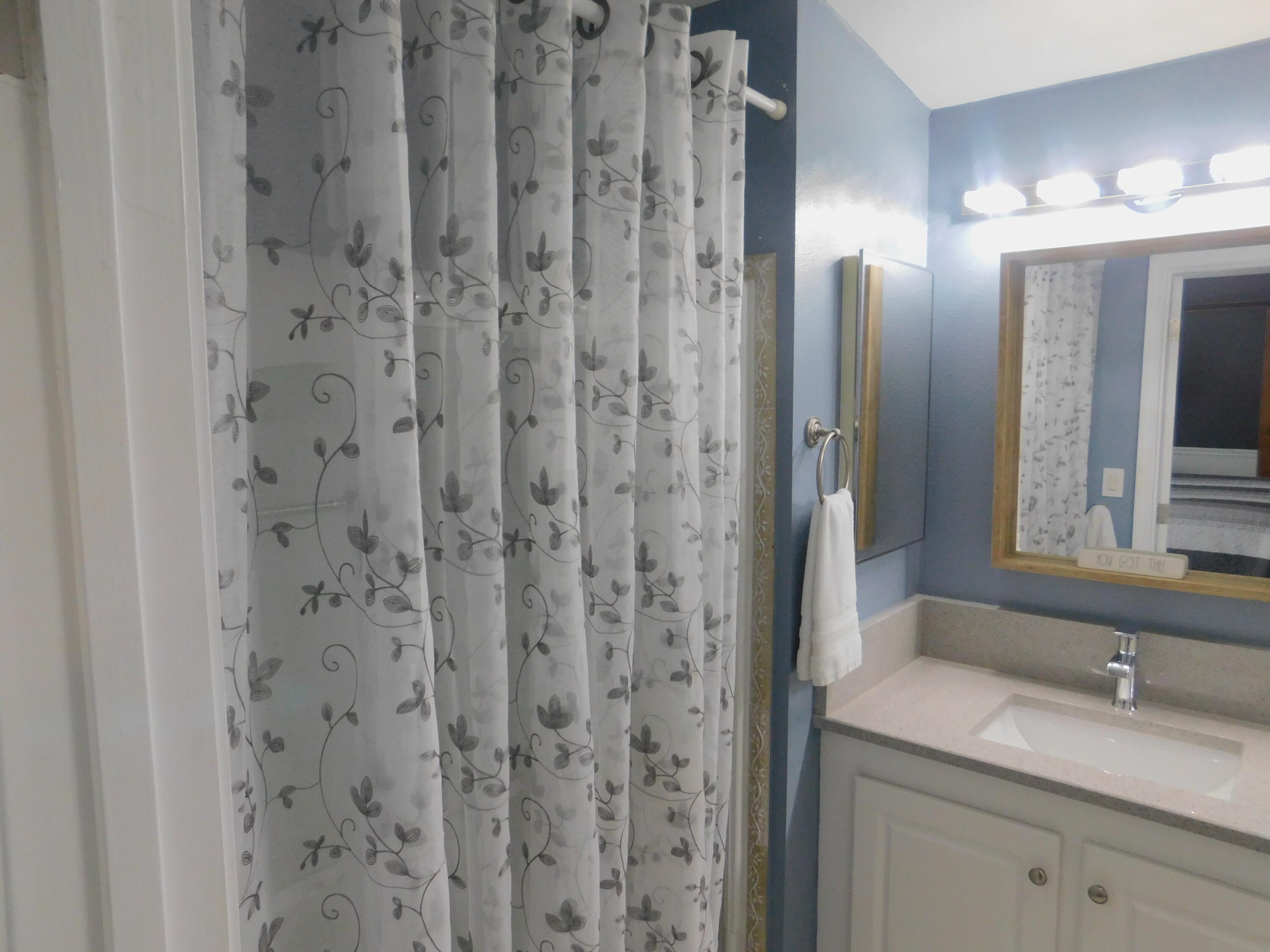 529 Hemingway Terrace, Unit 8 Fort Pierce, FL 34982 - Photo 20 of 24 a bathroom with a granite countertop sink and a mirror