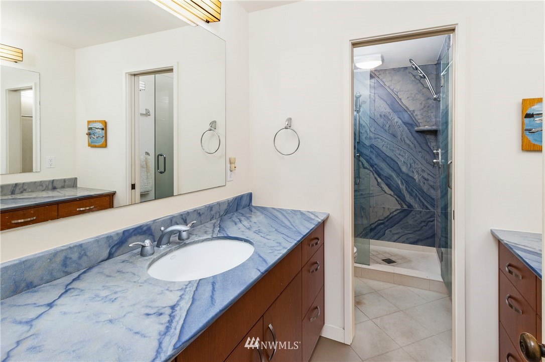 184 Armadale Road, Unit 5 Friday Harbor, WA 98250 - Photo 12 of 23 a bathroom with a granite countertop sink a mirror and a shower