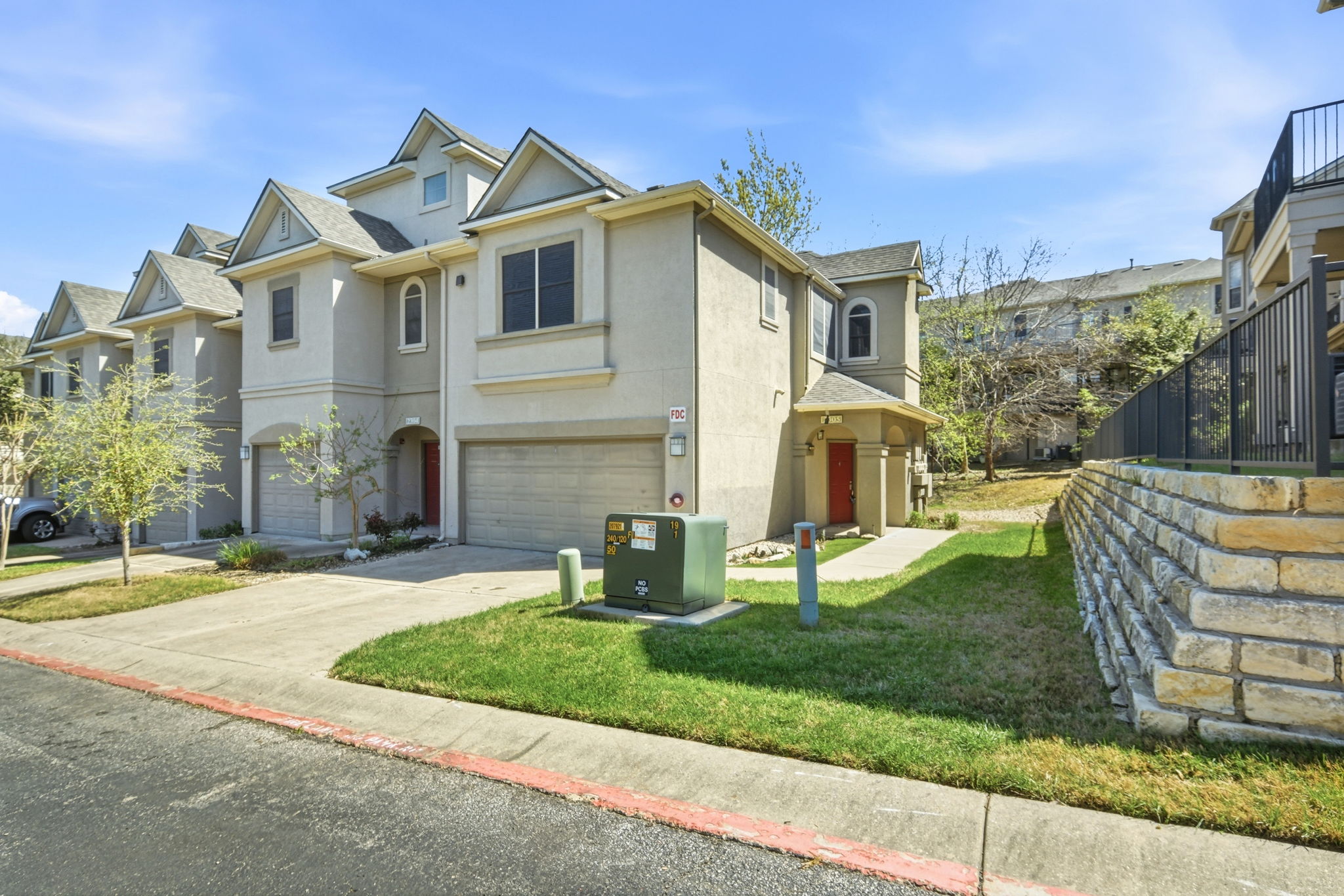 11203 Ranch Road 2222, Unit 2305 Austin, TX 78732 - Photo 1 of 19 View of front facade featuring an attached garage, stucco siding, concrete driveway, a front yard, and a residential view