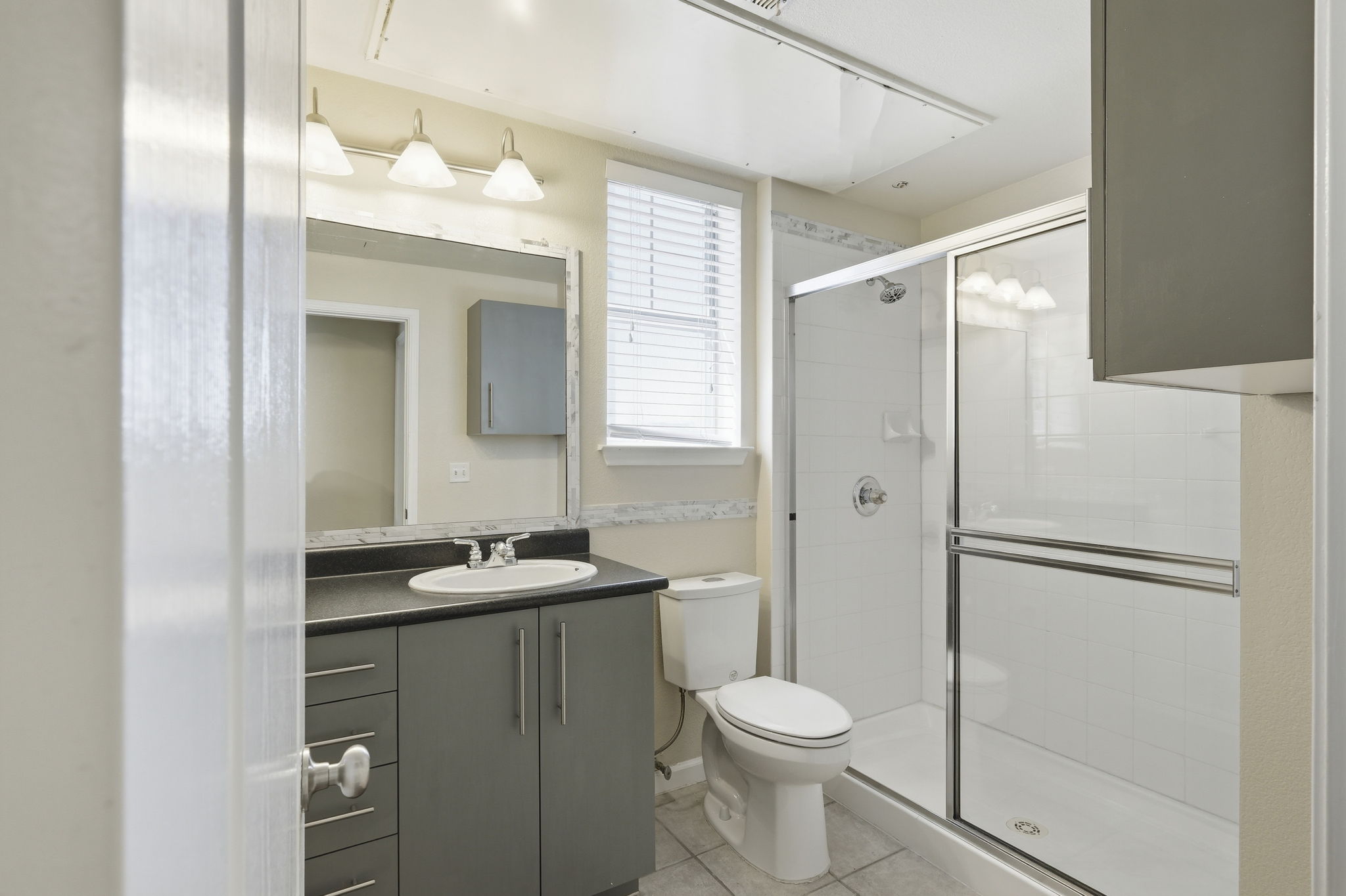 11203 Ranch Road 2222, Unit 2305 Austin, TX 78732 - Photo 12 of 19 Full bath with vanity, a shower stall, and light tile patterned floors