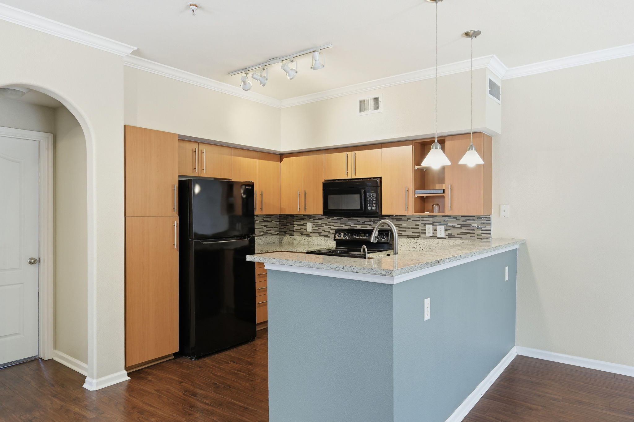 11203 Ranch Road 2222, Unit 2305 Austin, TX 78732 - Photo 7 of 19 Kitchen featuring a peninsula, black appliances, light stone counters, ornamental molding, and backsplash