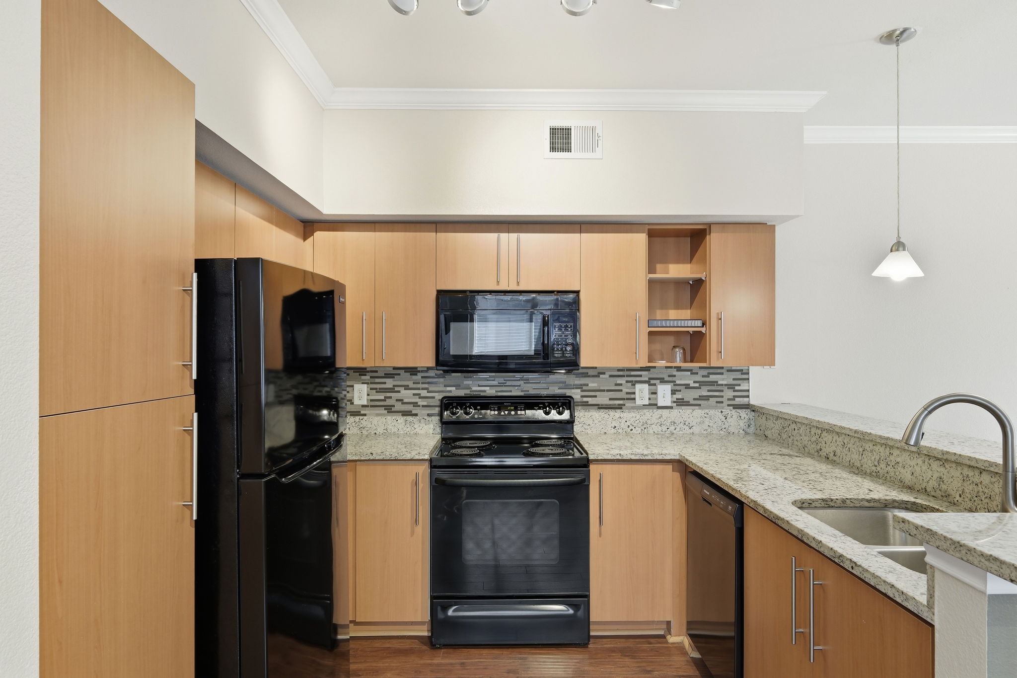 11203 Ranch Road 2222, Unit 2305 Austin, TX 78732 - Photo 8 of 19 Kitchen featuring black appliances, light stone counters, pendant lighting, crown molding, and a peninsula
