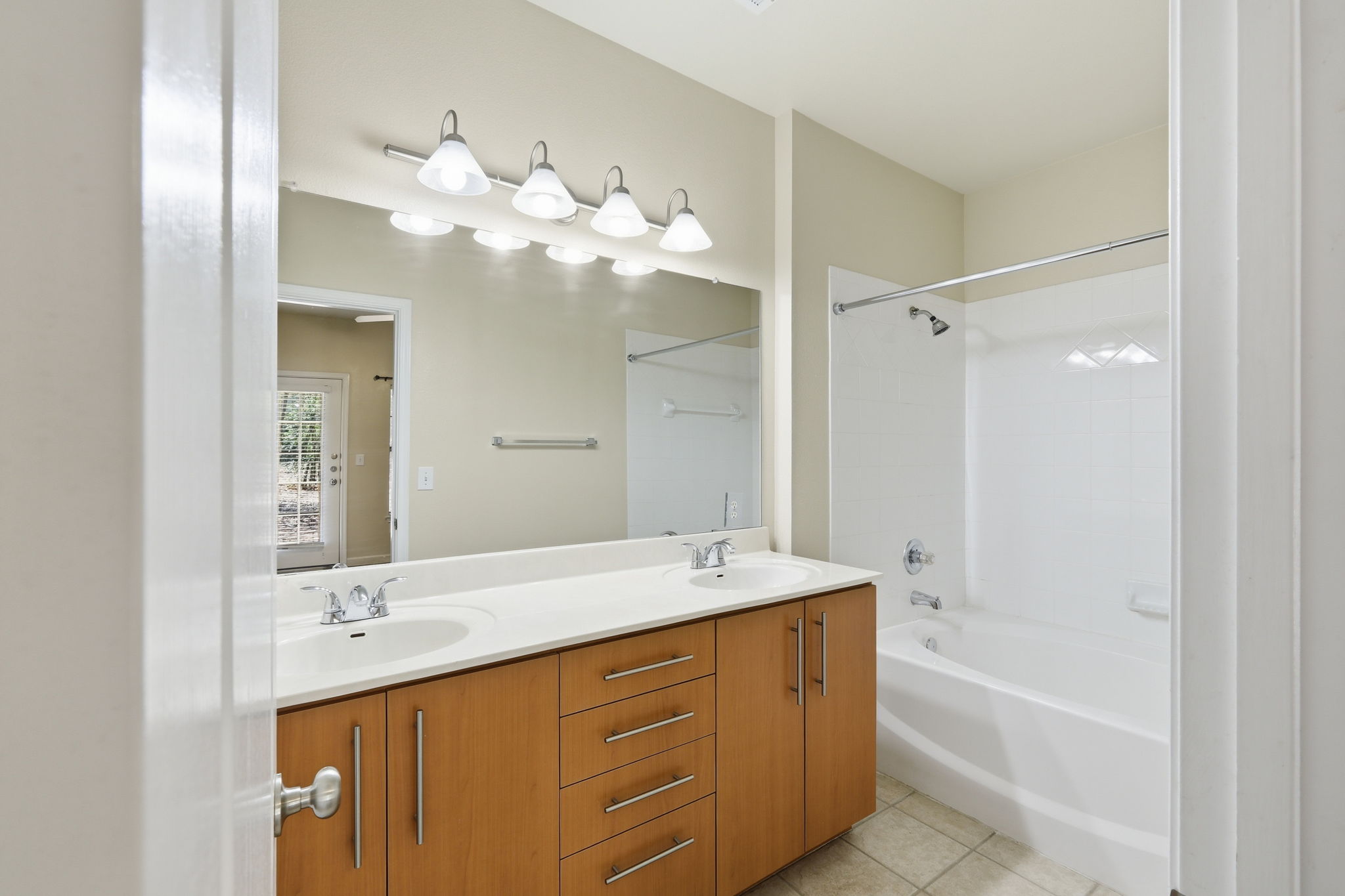 11203 Ranch Road 2222, Unit 2305 Austin, TX 78732 - Photo 10 of 19 Full bath with double vanity, light tile patterned flooring, and bathtub / shower combination