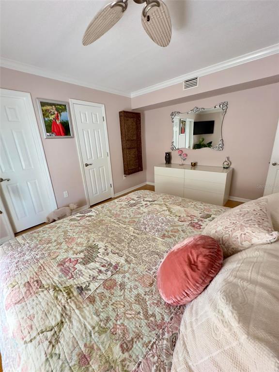 8911 Blind Pass Road, Unit 220 St. Pete Beach, FL 33706 - Photo 44 of 67 a bedroom with a large bed and a flat screen tv
