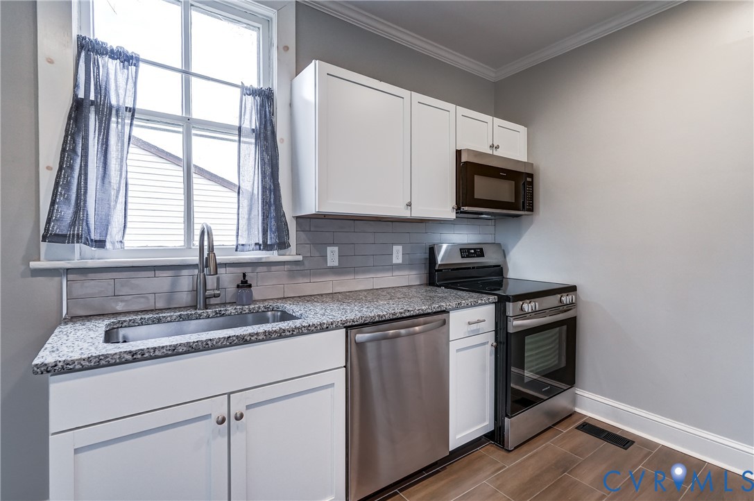 418 4th Street West Point, VA 23181 - Photo 14 of 36 a kitchen with stainless steel appliances granite countertop white cabinets a sink and a window