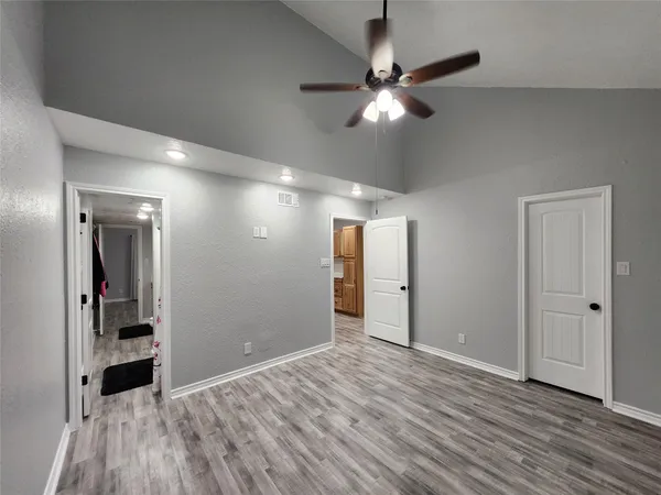 a view of an empty room with wooden floor