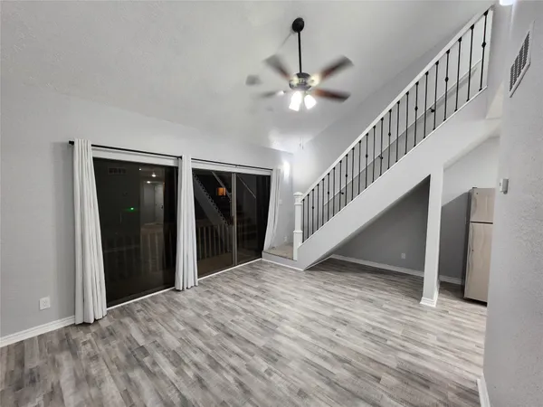 a view of a hallway with wooden floor and staircase