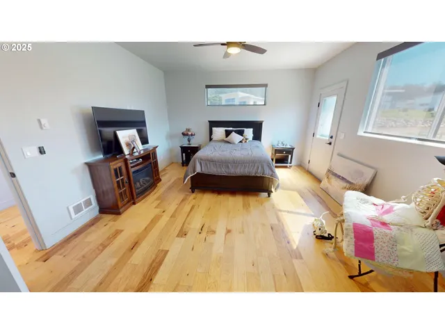 a bedroom with a bed and wooden floor