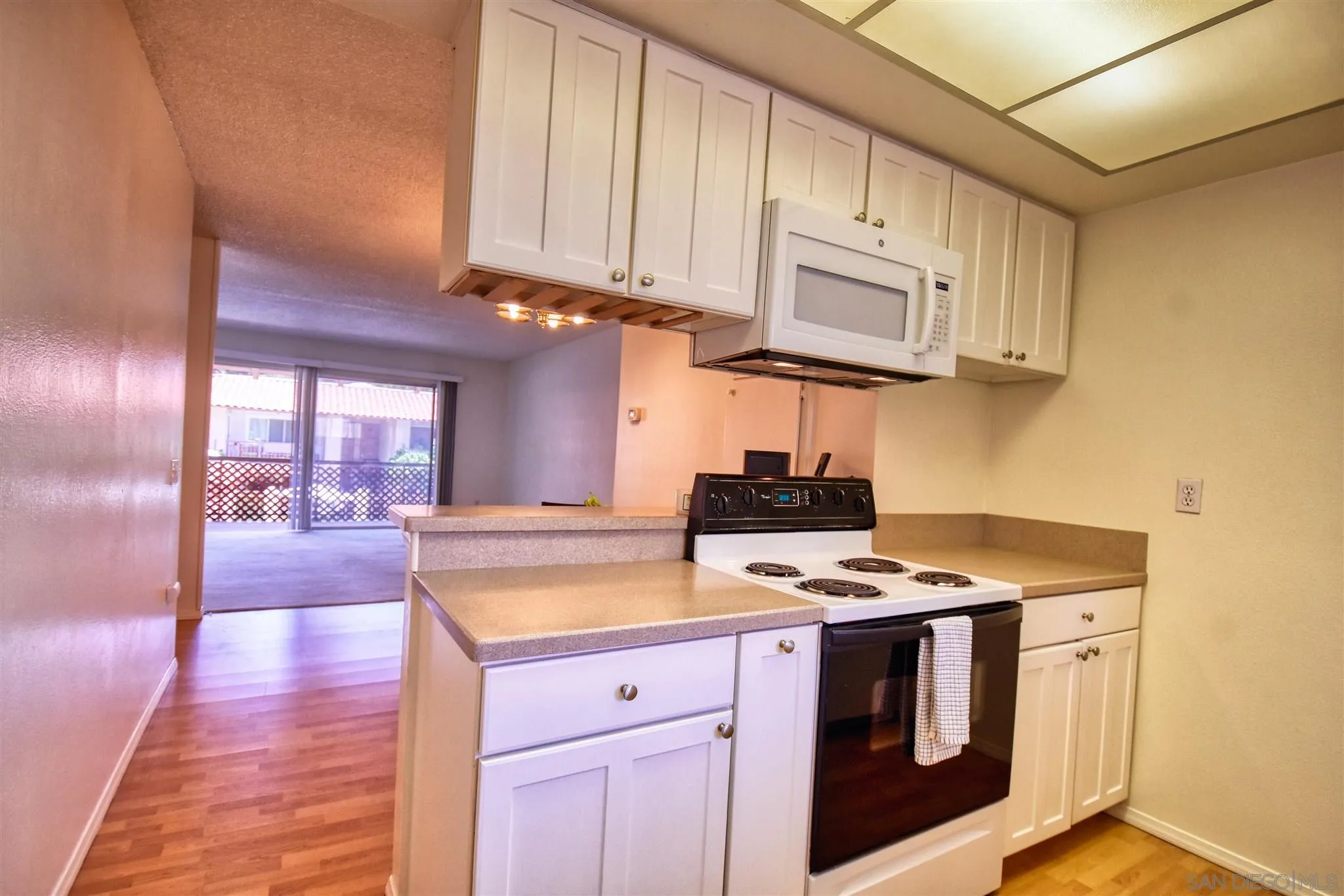 6069 Rancho Mission Road, Unit 202 San Diego, CA 92108 - Photo 2 of 26 a kitchen with stainless steel appliances granite countertop a stove a sink and a microwave