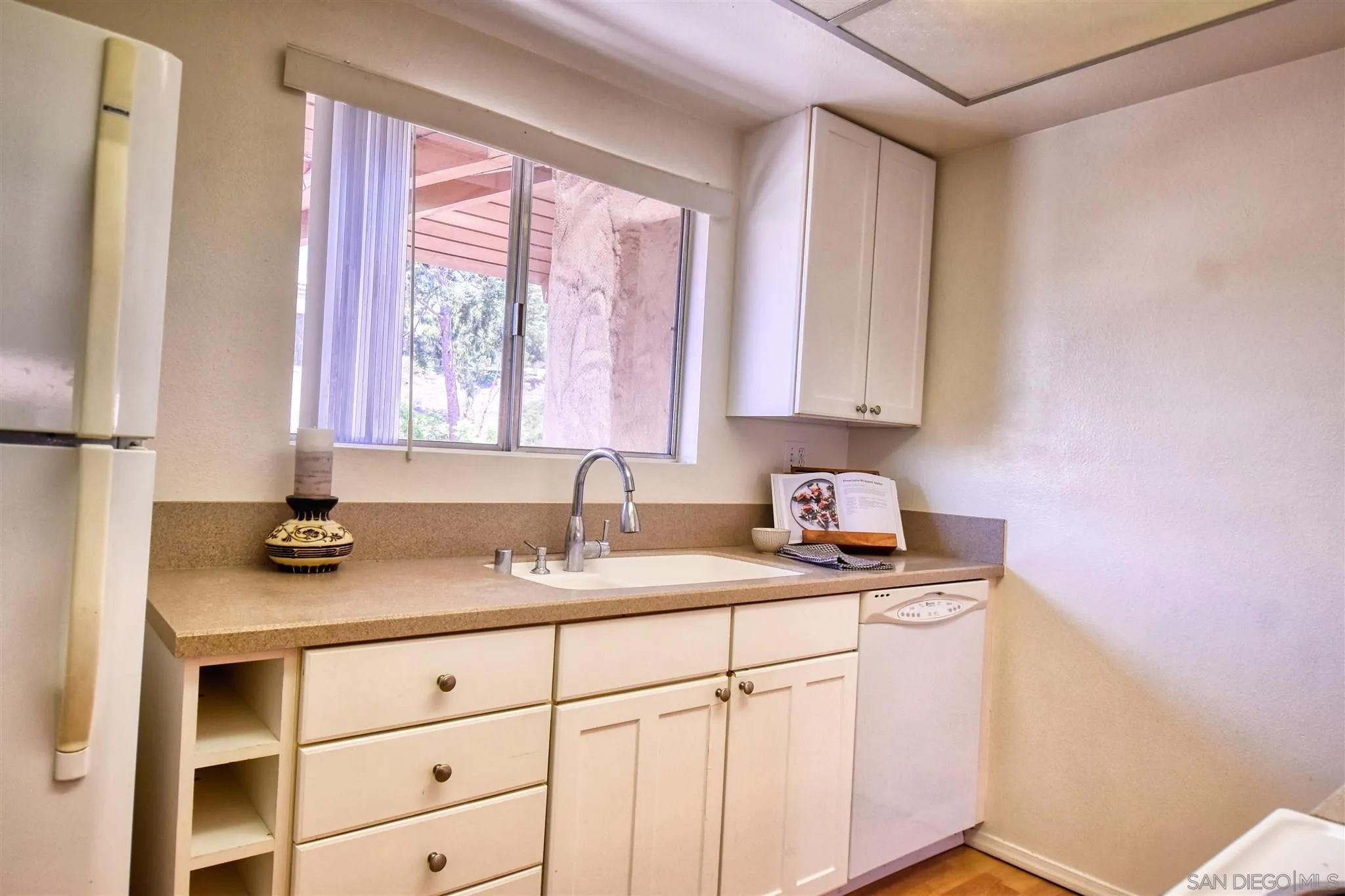 6069 Rancho Mission Road, Unit 202 San Diego, CA 92108 - Photo 4 of 26 a kitchen with granite countertop a sink cabinets and window