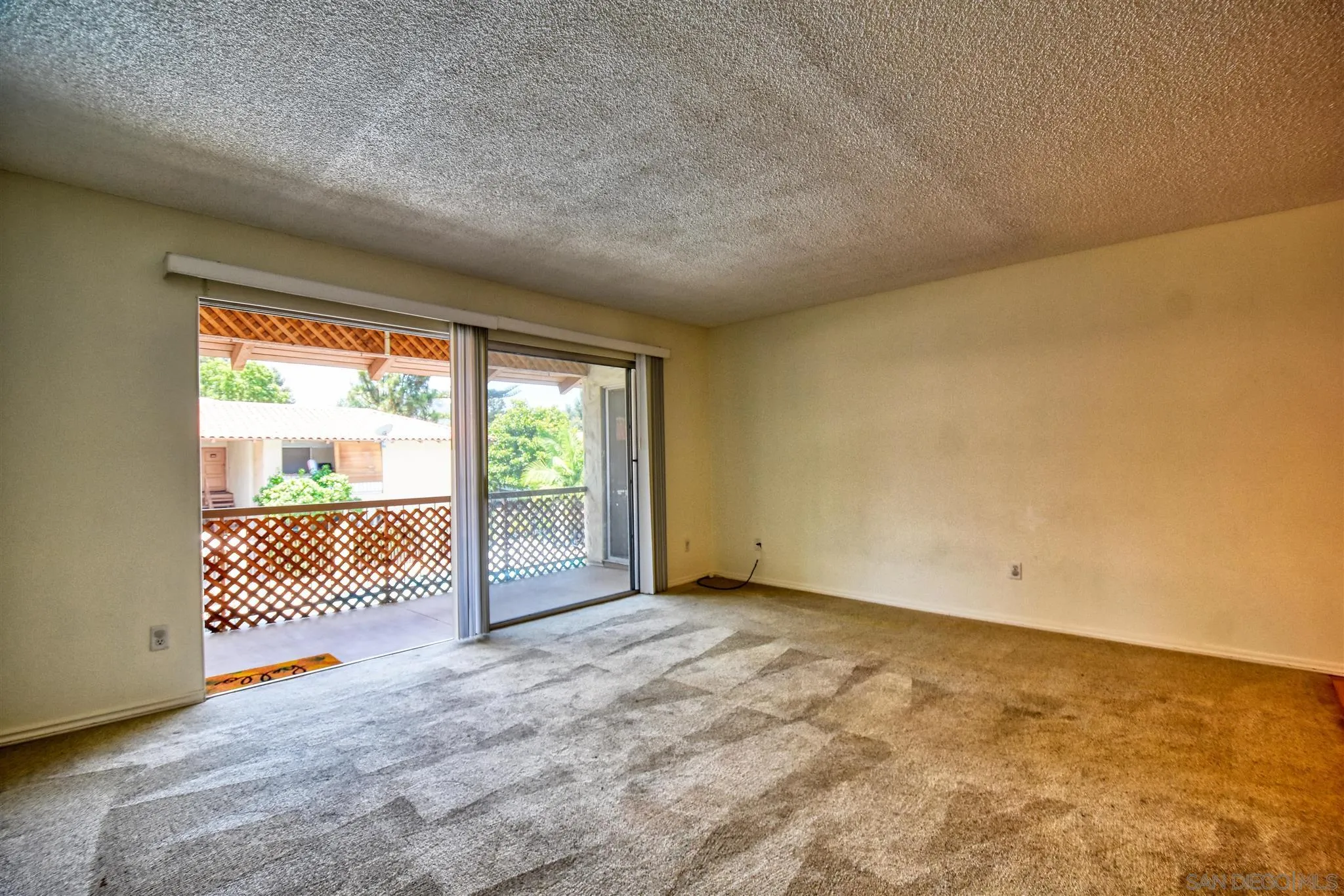 6069 Rancho Mission Road, Unit 202 San Diego, CA 92108 - Photo 8 of 26 a view of a room with sliding door and wooden floor