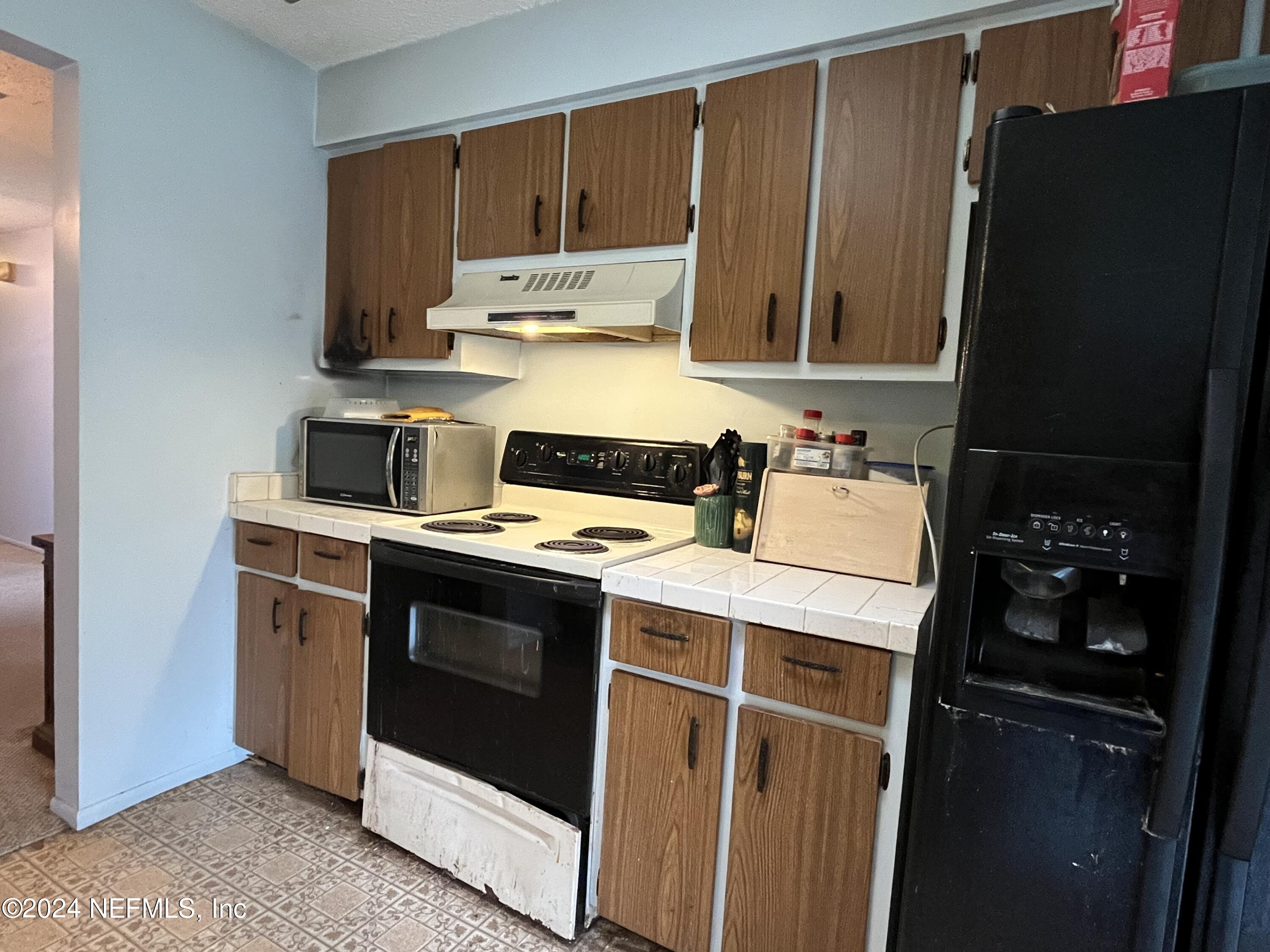 228 Lily Road St. Augustine, FL 32086 - Photo 11 of 34 a kitchen with a refrigerator stove and sink