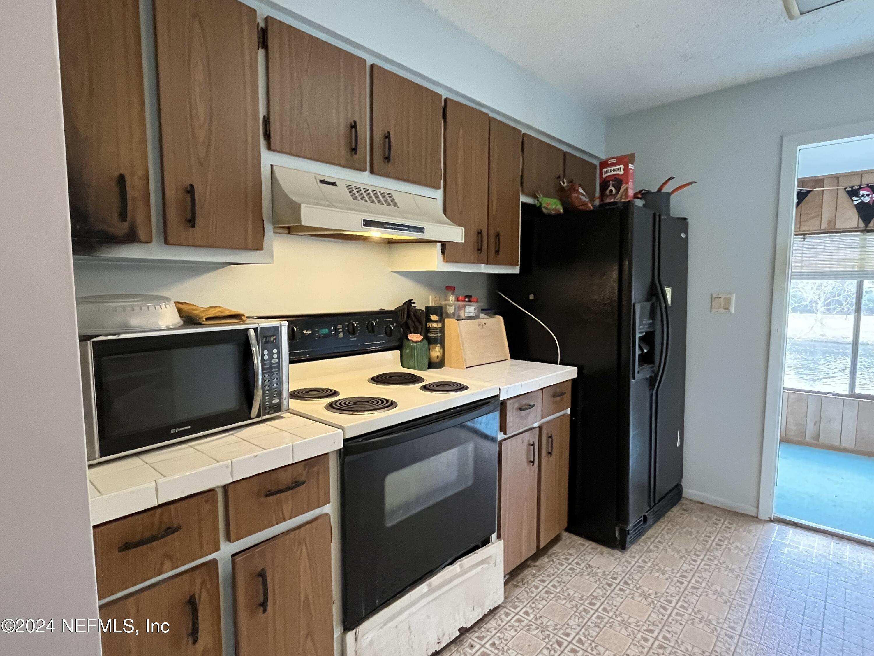 228 Lily Road St. Augustine, FL 32086 - Photo 10 of 34 a kitchen with stainless steel appliances granite countertop a refrigerator stove and sink