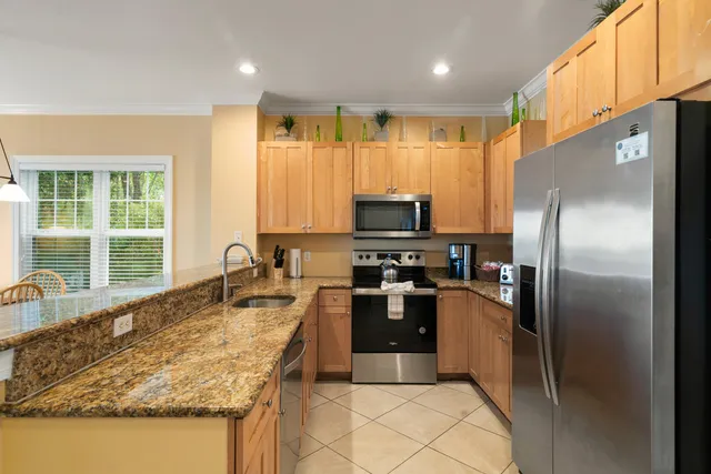 a dining hall with stainless steel appliances a table and chairs