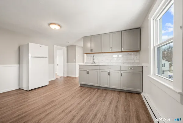 a kitchen with wooden floors and white appliances