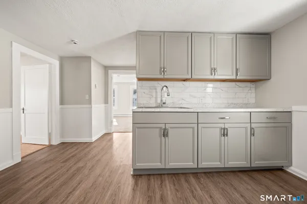 a kitchen with white cabinets and sink