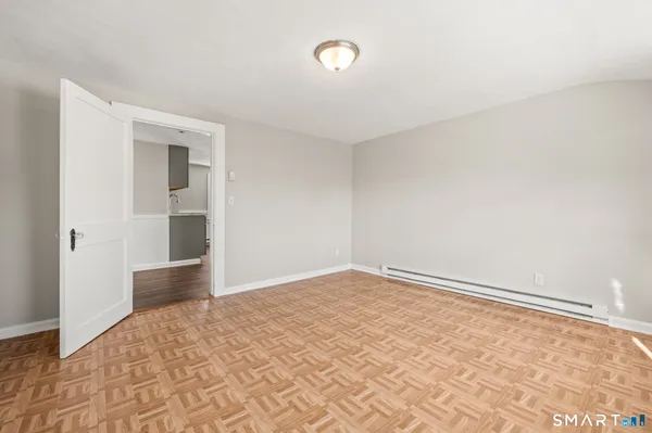 a view of empty room with wooden floor