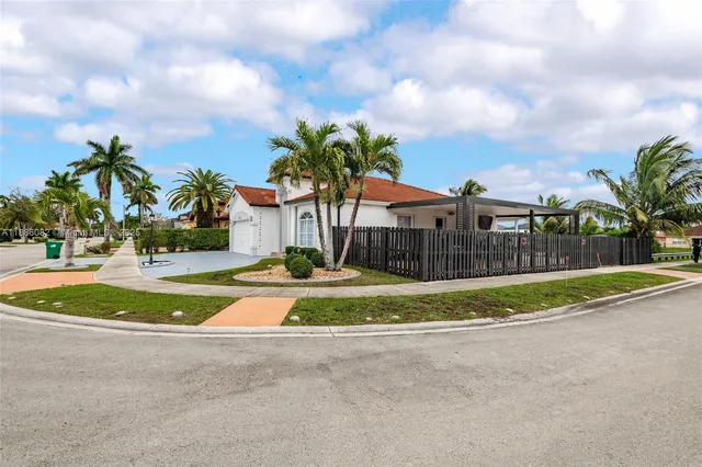 a view of a house with a big yard and a large trees
