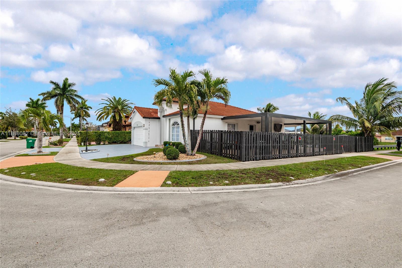 a view of a house with a big yard and a large trees