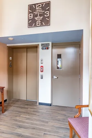 a view of a hallway with wooden floor and closet