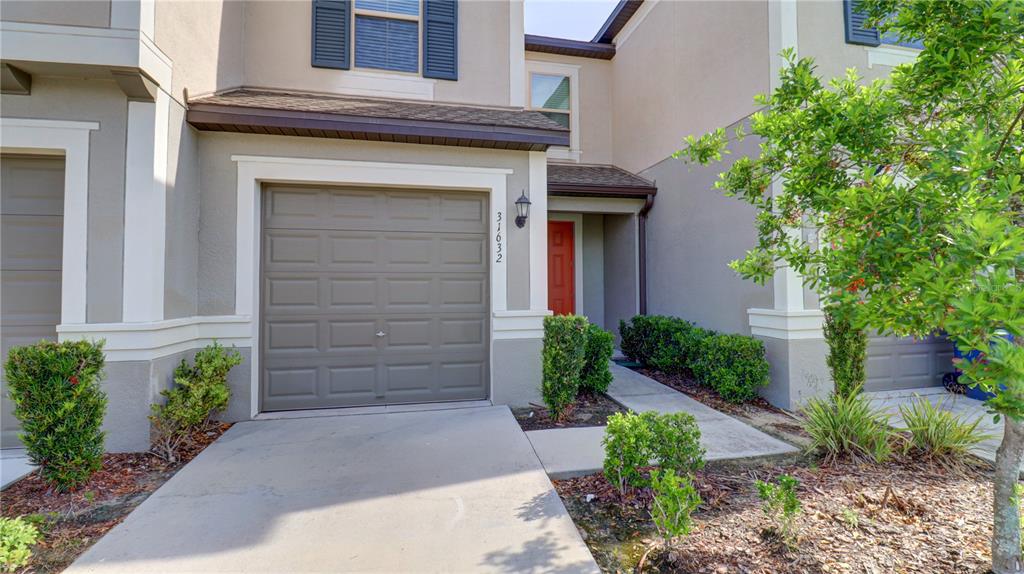31632 Blue Passing Loop Wesley Chapel, FL 33545 - Photo 2 of 48 a stone house with a outdoor space