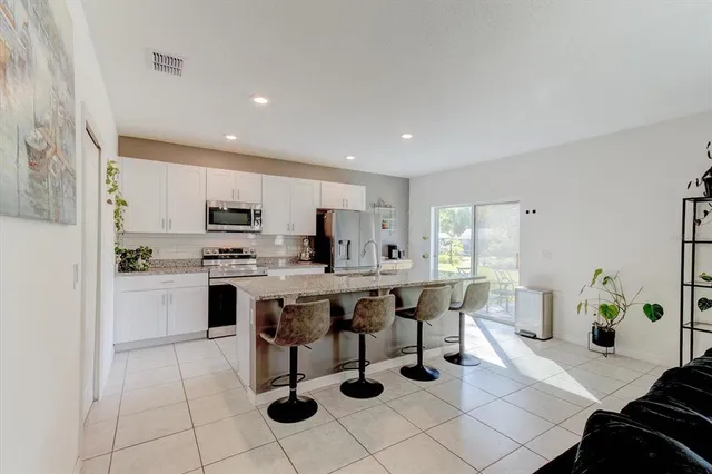 a kitchen with a sink white cabinets and stainless steel appliances