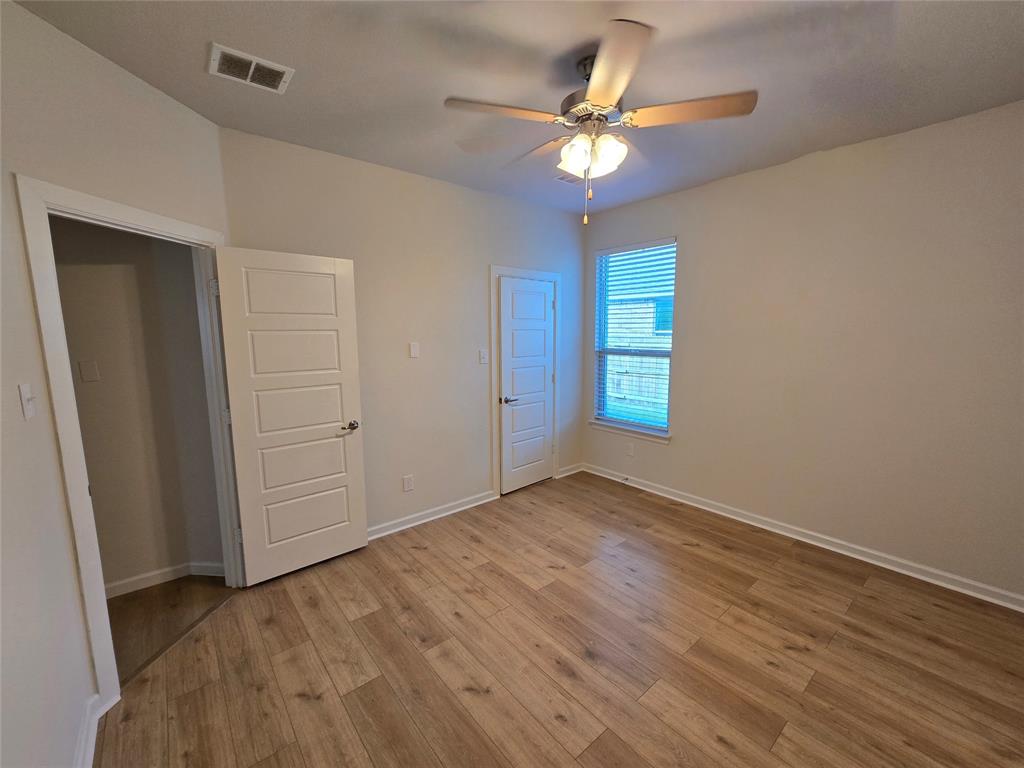 508 Williams Way Van Alstyne, TX 75495 - Photo 19 of 26 an empty room with wooden floor chandelier fan and windows