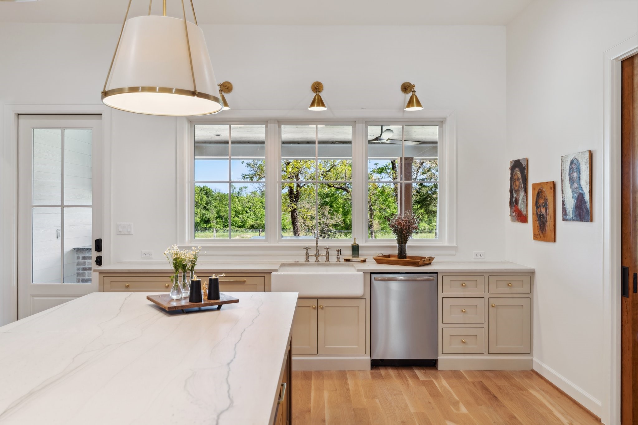 4052 Kuykendall Road Bellville, TX 77418 - Photo 7 of 40 Explore a chef’s dream kitchen featuring open shelving, sleek Frigidaire appliances, handy utensil drawers, stylish appliance cabinets, a charming farm sink, and custom lighting—all designed to inspire culinary creativity.