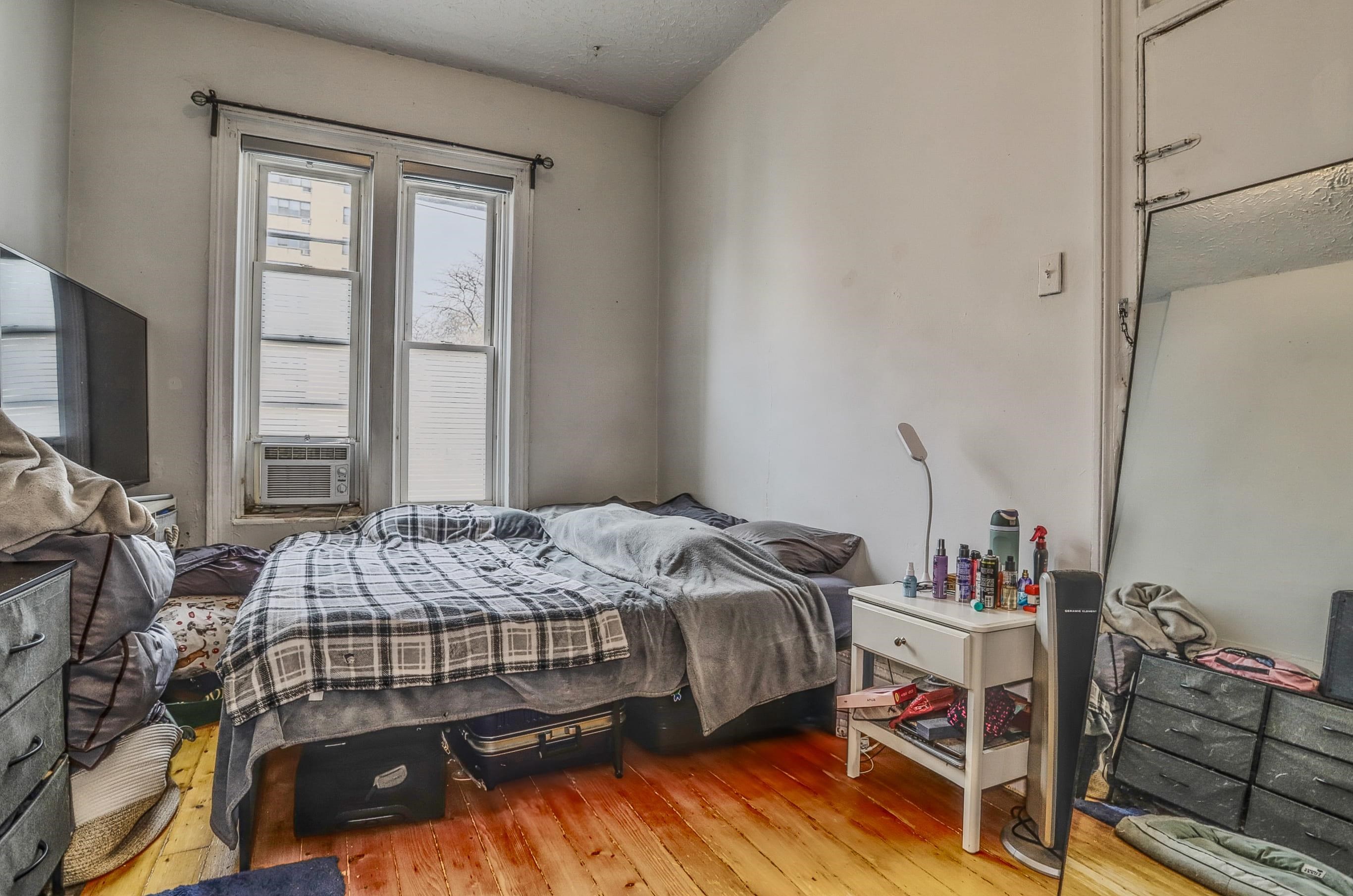 521 Willow Avenue, Unit 1R Hoboken, NJ 07030 - Photo 10 of 15 a bedroom with a bed and a flat tv screen on a dresser