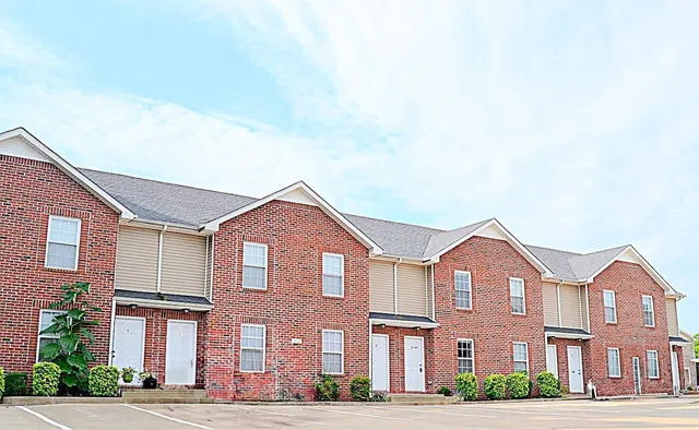 a front view of a brick house with a yard