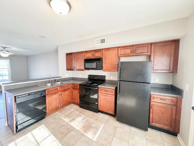 a kitchen with stainless steel appliances granite countertop a refrigerator stove top oven and sink