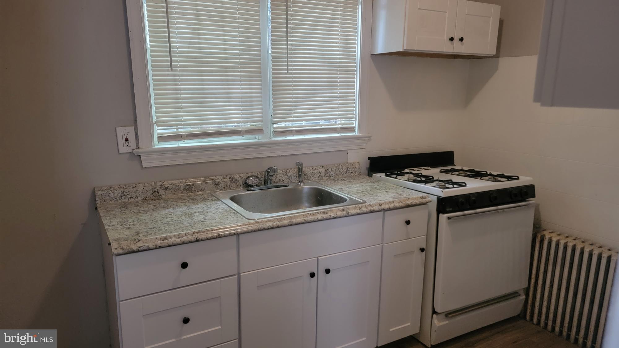 3208 D Street Philadelphia, PA 19134 - Photo 10 of 33 a kitchen with granite countertop white cabinets sink and window