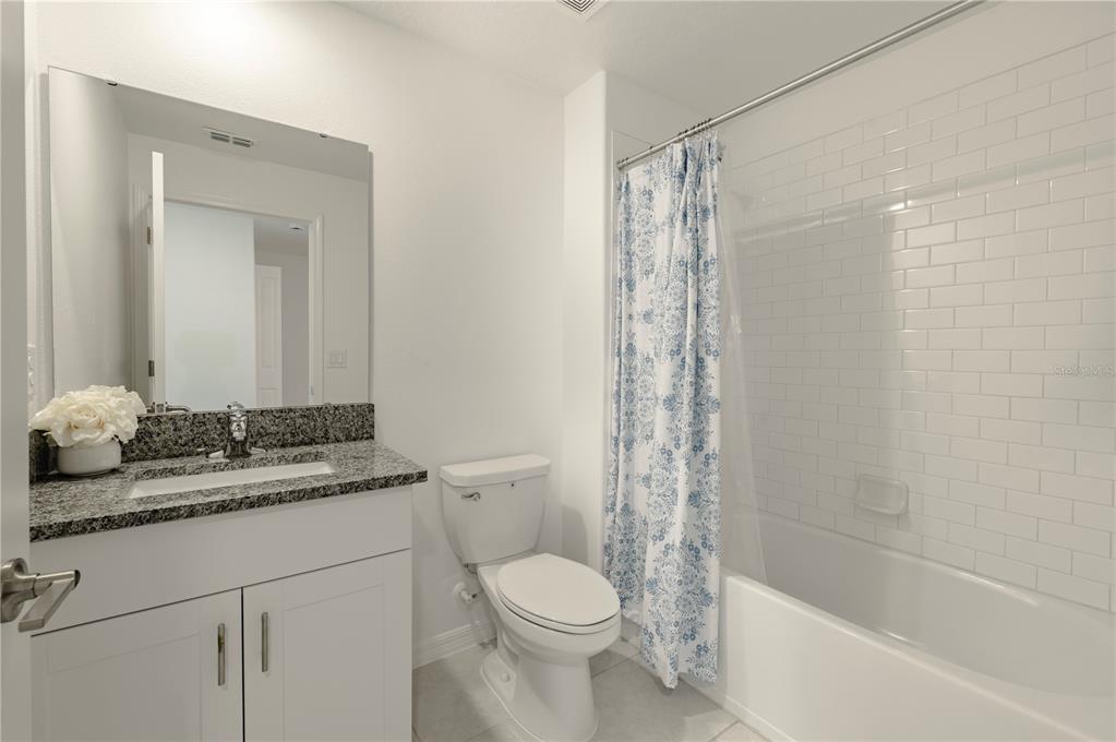 21395 Darter Road Land O' Lakes, FL 34638 - Photo 16 of 22 a bathroom with a granite countertop sink toilet and shower