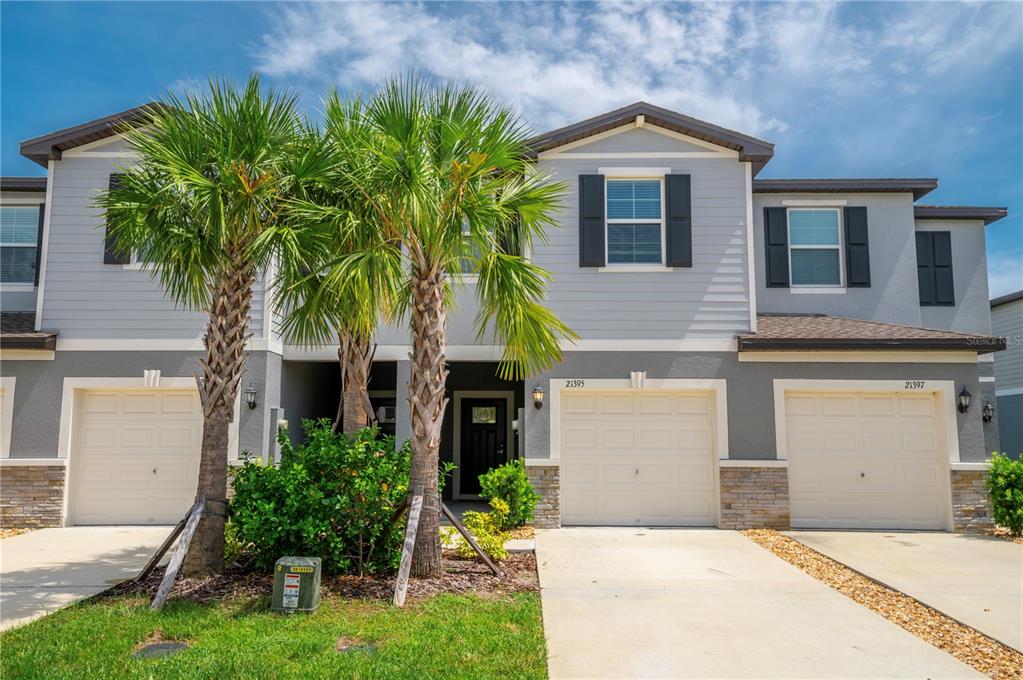 21395 Darter Road Land O' Lakes, FL 34638 - Photo 2 of 22 a front view of a house with a yard and garage