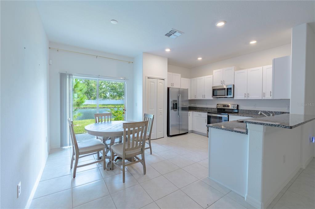 21395 Darter Road Land O' Lakes, FL 34638 - Photo 7 of 22 a kitchen with refrigerator a sink and chairs