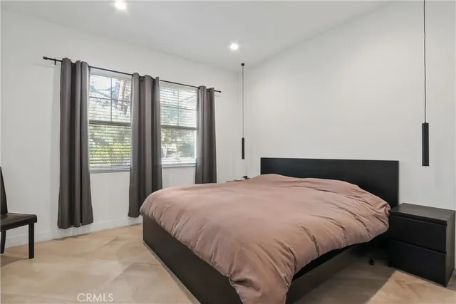 a large bed sitting in a bedroom next to a window