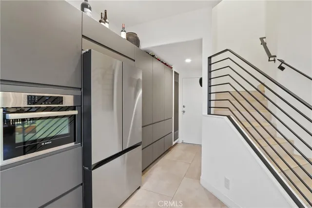 a kitchen view with cabinets a refrigerator and a stove top oven