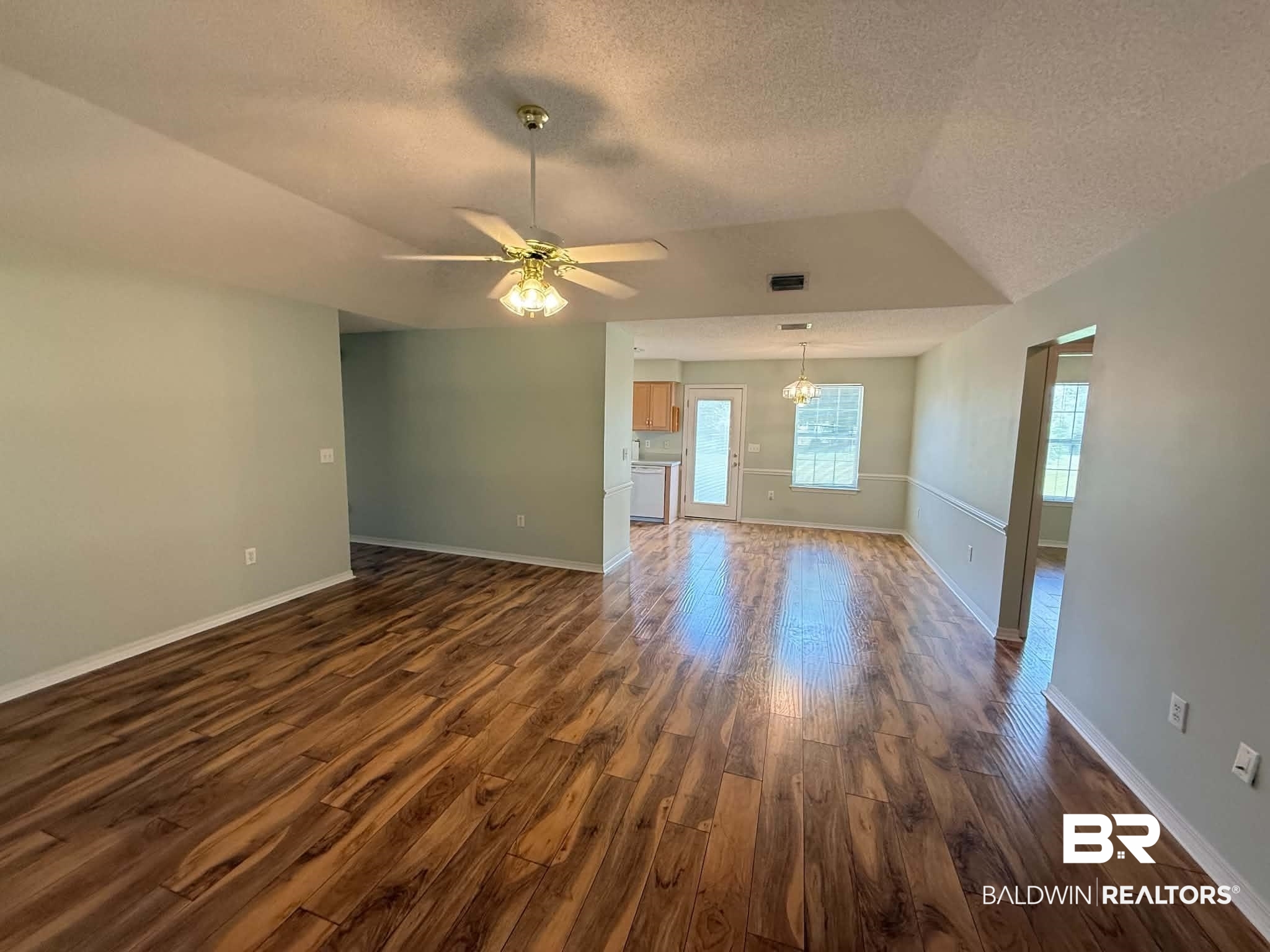 123 Pennbrooke Loop Foley, AL 36535 - Photo 17 of 49 Expansive living area featuring wood-finish flooring, vaulted ceilings, and a ceiling fan with integrated lighting