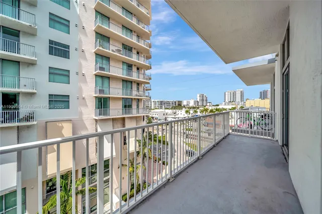 a view of hallway with a large window and a kitchen view