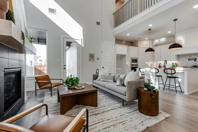 a living room with furniture wooden floor and kitchen view