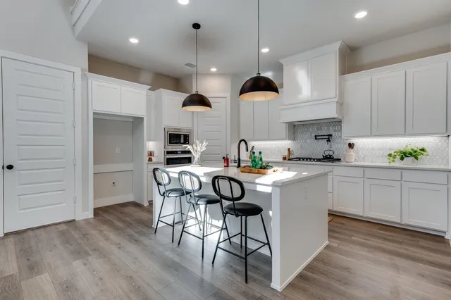 a kitchen with stainless steel appliances kitchen island granite countertop a stove a sink and a refrigerator