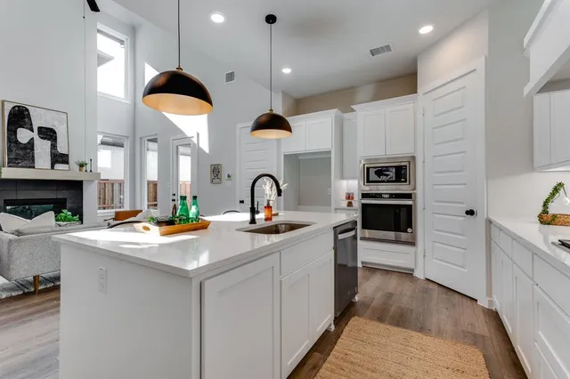 a kitchen with kitchen island a sink stainless steel appliances and cabinets