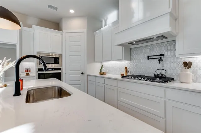 a kitchen with a sink a stove and cabinets